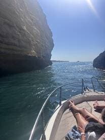 A scenic view from a boat navigating through a stunning coastal landscape, with guests relaxing on the deck — perfect for exploring beautiful waterways.