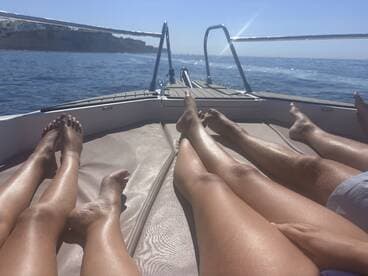 A group enjoys a relaxing day on the boat, sunbathing and soaking in the beautiful ocean views — perfect for a summer getaway.