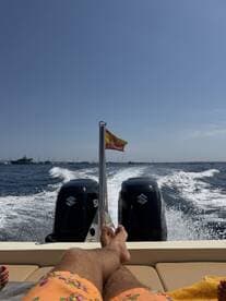 A relaxing moment on a boat with feet up, enjoying the sea breeze and the view of the horizon, perfect for a day of leisure on the water.