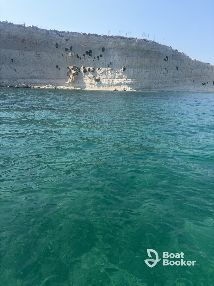 A stunning view of a rocky coastline against clear turquoise waters, perfect for showcasing the natural beauty of the area.