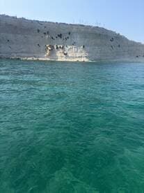 A stunning view of a rocky coastline against clear turquoise waters, perfect for showcasing the natural beauty of the area.