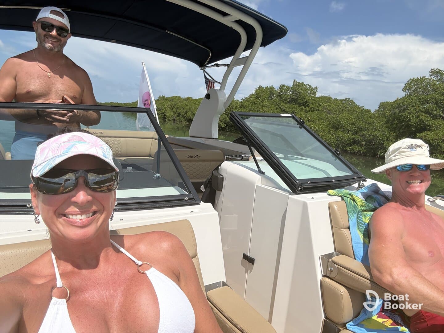 A cheerful group enjoys a sunny day on a boat, showcasing smiles and relaxation in a beautiful setting — perfect for a fun day on the water.