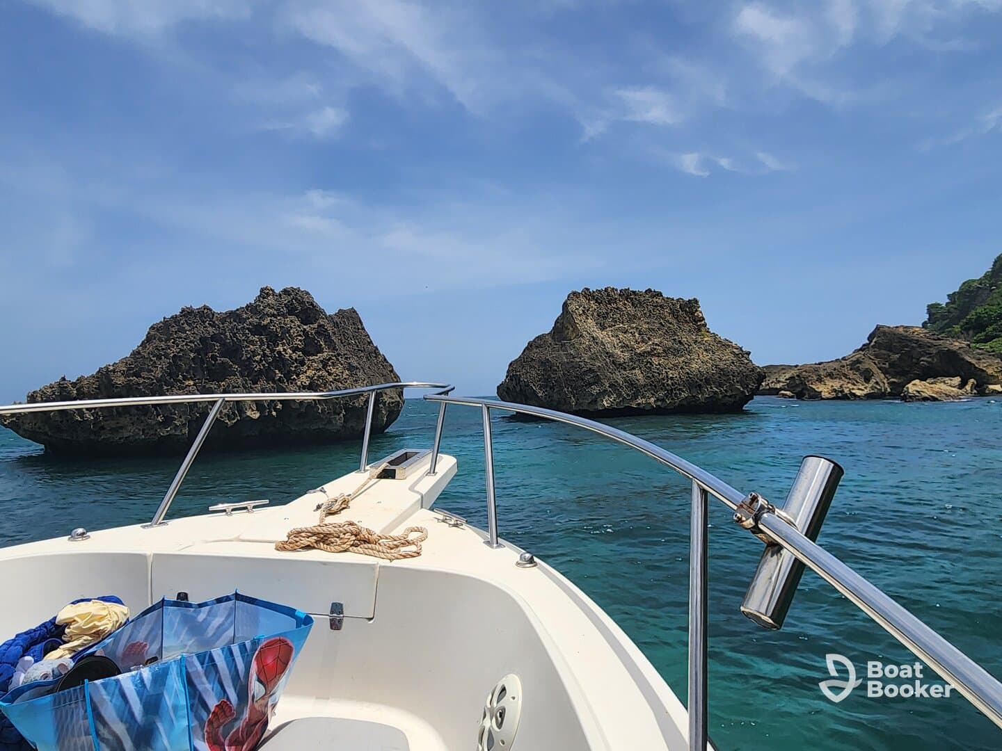 A scenic view from the bow of a boat navigating through clear waters, showcasing unique rock formations in the distance — perfect for exploring coastal landscapes.