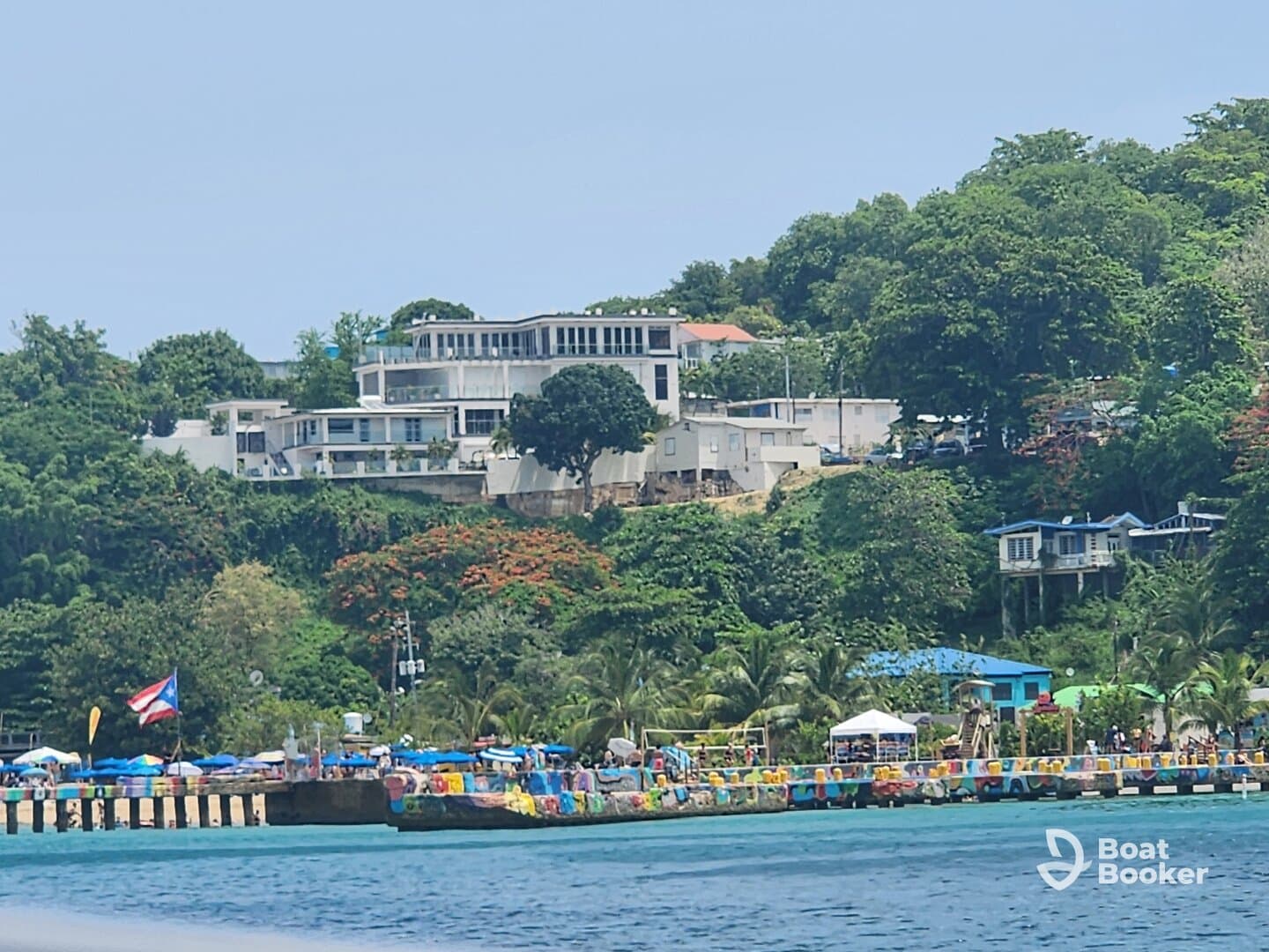 A vibrant harbor scene with colorful stalls and a picturesque coastline, showcasing the lively atmosphere of the area.