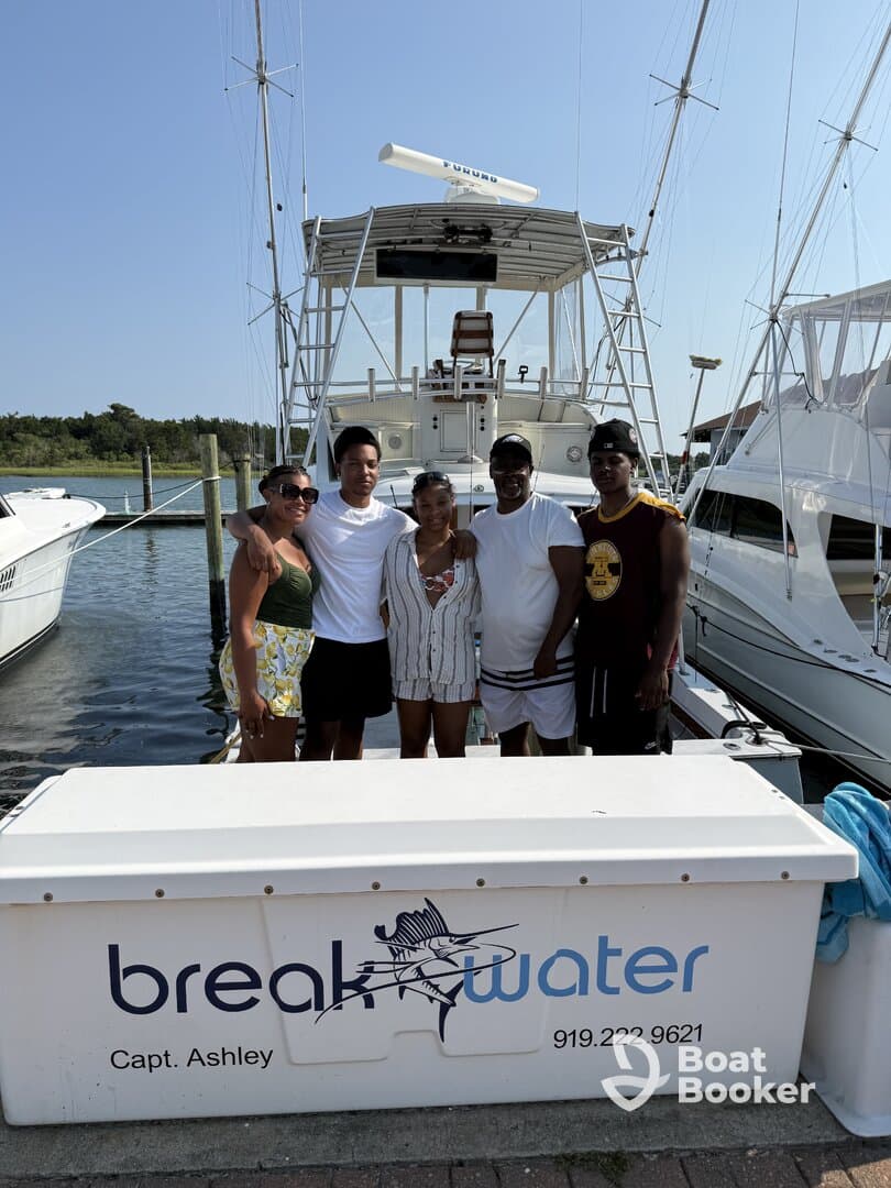 A cheerful group poses in front of their boat, capturing a memorable moment before setting sail — perfect for family outings or group adventures on the water.