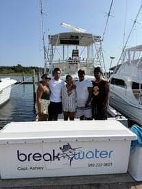 A cheerful group poses in front of their boat, capturing a memorable moment before setting sail — perfect for family outings or group adventures on the water.