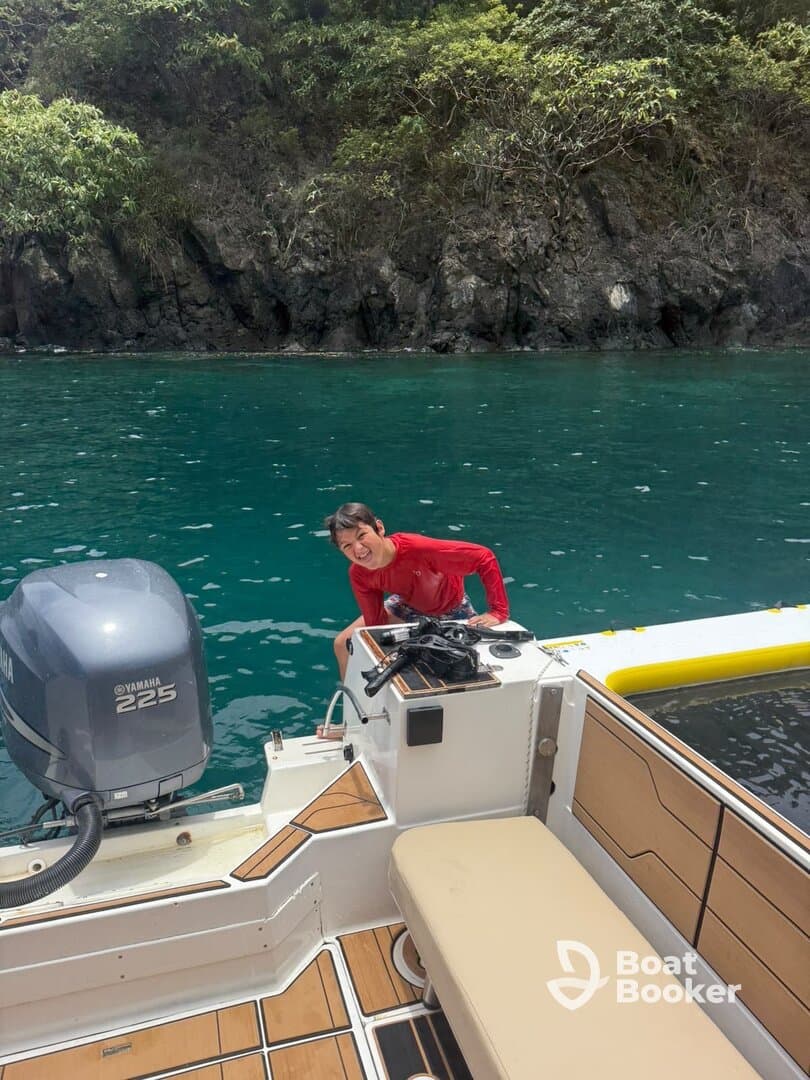 A joyful moment captured on a boat, showcasing a person enjoying the beautiful turquoise waters — perfect for adventure seekers and water enthusiasts.