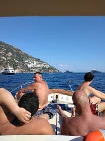 A group of friends relaxes on the deck of a boat, enjoying the sun and ocean views — perfect for a day of leisure on the water.