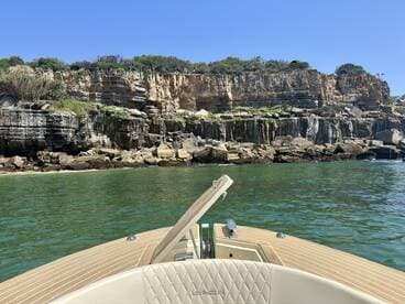 A scenic view from the bow of a boat, showcasing stunning cliffs and clear waters — perfect for exploring coastal landscapes.