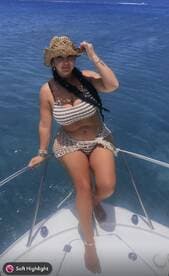 A woman enjoys the sun on the bow of a boat, showcasing a perfect day on the water — ideal for summer adventures and relaxation.