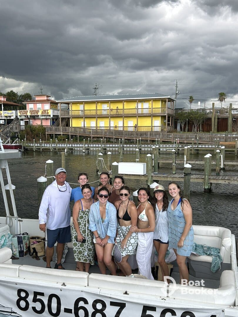 A lively group of friends poses on a boat, ready for a fun day on the water, showcasing the perfect atmosphere for celebrations and gatherings.