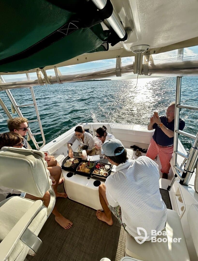 A lively group enjoys a delicious meal aboard a boat, capturing moments of joy and togetherness on the water.