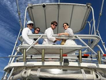 A cheerful group of friends enjoys their time on a boat, capturing the essence of fun and camaraderie on the water.
