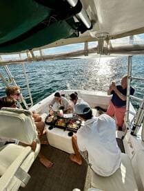 A lively group enjoys a delicious meal aboard a boat, capturing moments of joy and togetherness on the water.