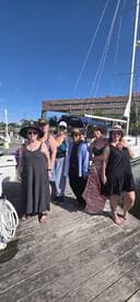 A joyful group of friends poses together at the dock, ready for a fun day on the water — perfect for celebrations and memorable outings.