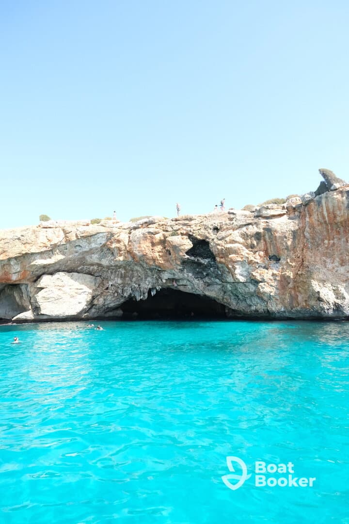 A stunning view of a natural cave with swimmers enjoying the vibrant turquoise waters — a perfect spot for adventure and exploration.
