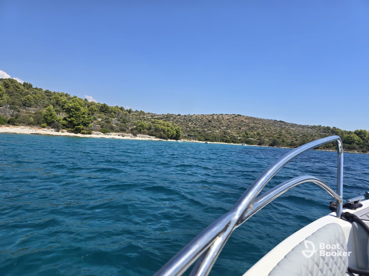 A scenic view from a boat cruising along a beautiful coastline, showcasing the vibrant blue waters and lush greenery — perfect for exploring hidden beaches and enjoying nature.