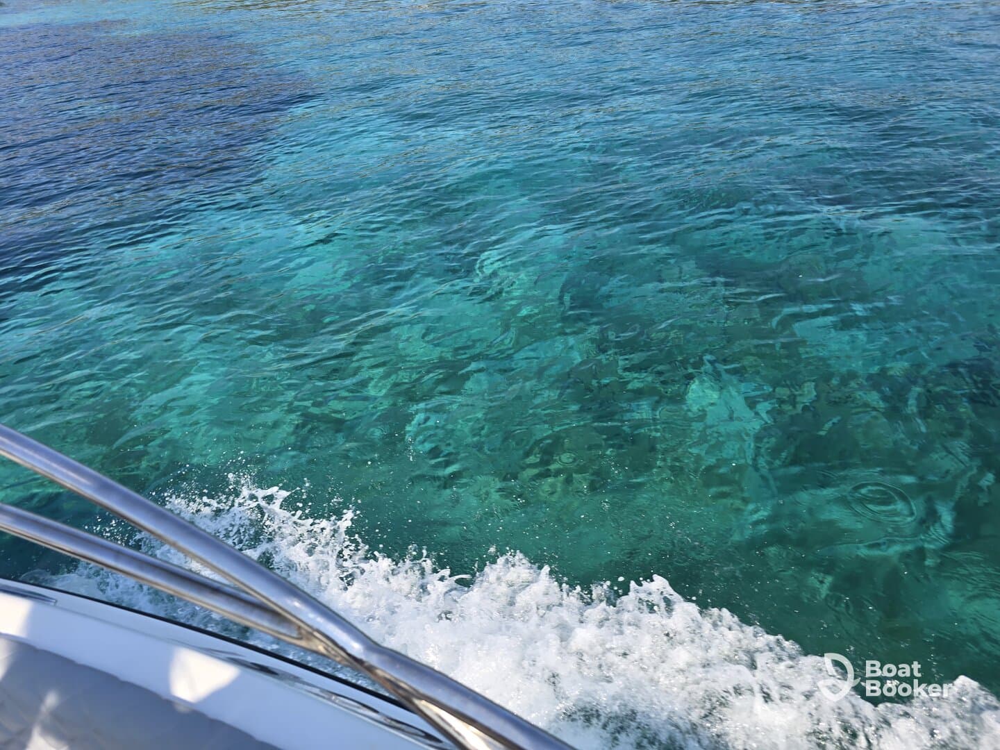 A view from the side of a boat cruising over crystal-clear waters, showcasing the vibrant underwater scenery below — perfect for exploring marine life.