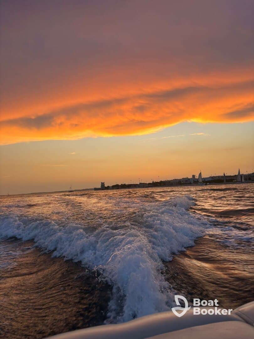 A stunning sunset over the water, capturing the vibrant colors reflecting on the waves — a perfect moment for evening boat rides.