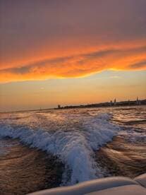 A stunning sunset over the water, capturing the vibrant colors reflecting on the waves — a perfect moment for evening boat rides.