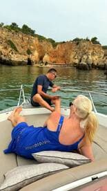 A couple enjoys a relaxing moment on a boat, surrounded by stunning coastal scenery — perfect for romantic getaways or leisurely days on the water.
