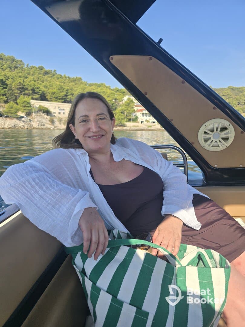 A woman relaxes on a boat, enjoying a sunny day by the water — a perfect moment for leisure and tranquility on the sea.