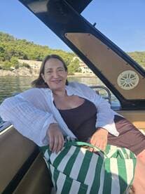 A woman relaxes on a boat, enjoying a sunny day by the water — a perfect moment for leisure and tranquility on the sea.