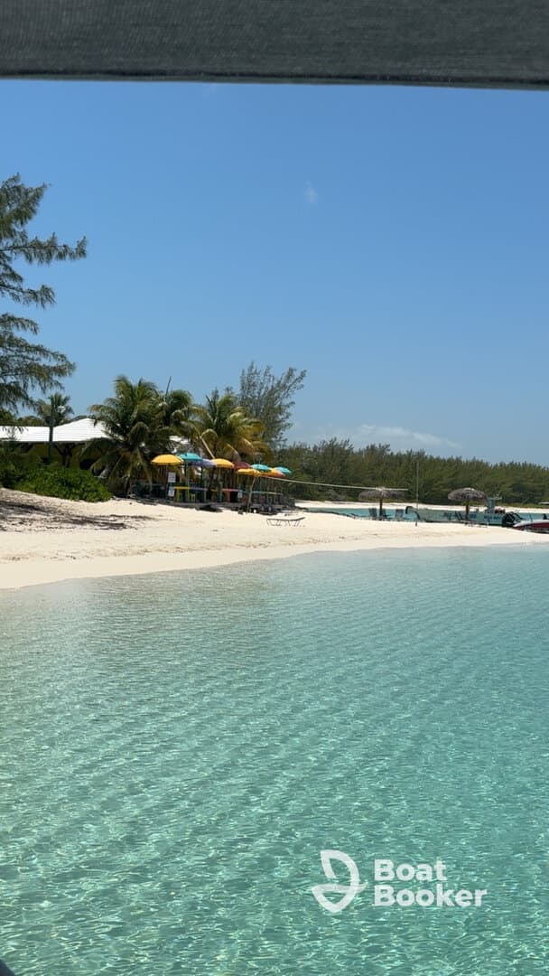 A serene view of a picturesque beach with clear turquoise waters and colorful umbrellas, perfect for a relaxing day by the coast.