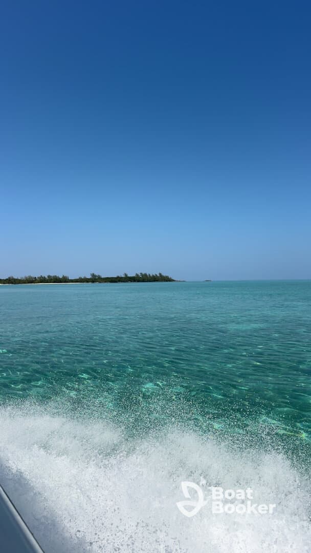 A stunning view of turquoise waters and a lush coastline, captured while cruising on a boat — perfect for showcasing the beauty of tropical destinations.