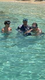 A group of snorkelers enjoy the clear waters, showcasing a fun underwater adventure experience perfect for family outings.