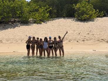 A lively group of friends enjoys a beach day, celebrating together in the water — perfect for summer fun and memorable gatherings.