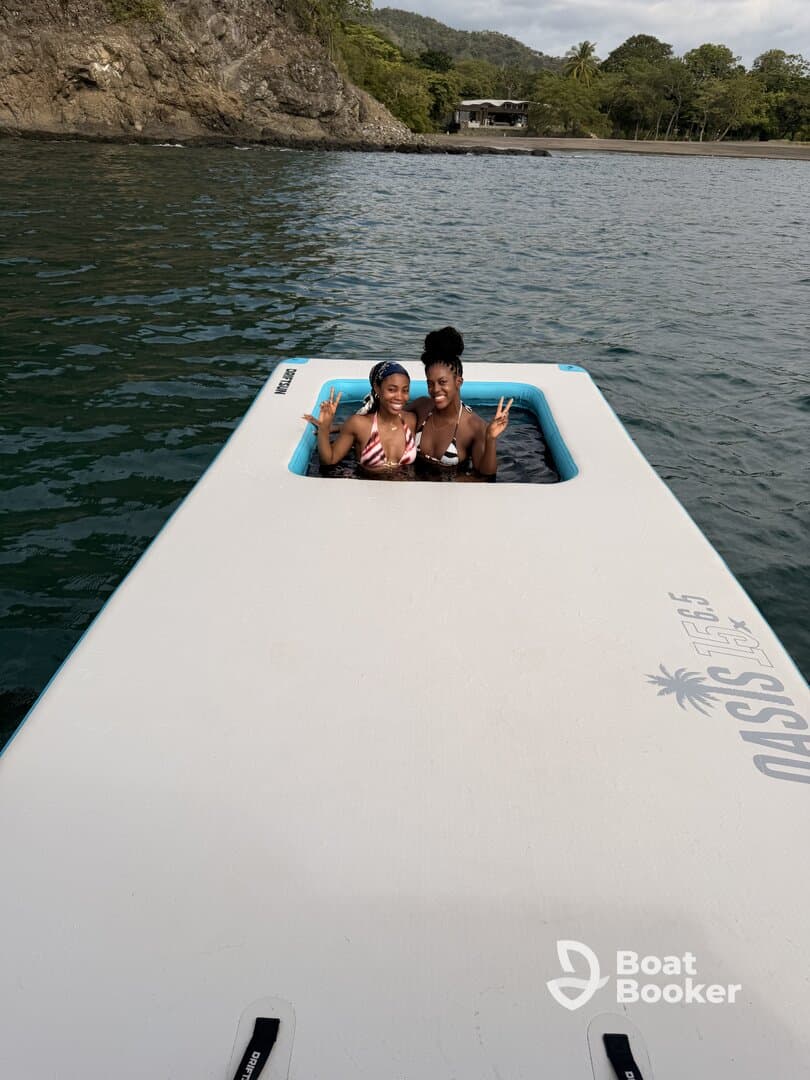 Two friends enjoy a fun day swimming on a floating mat in the ocean, showcasing the perfect blend of relaxation and adventure.
