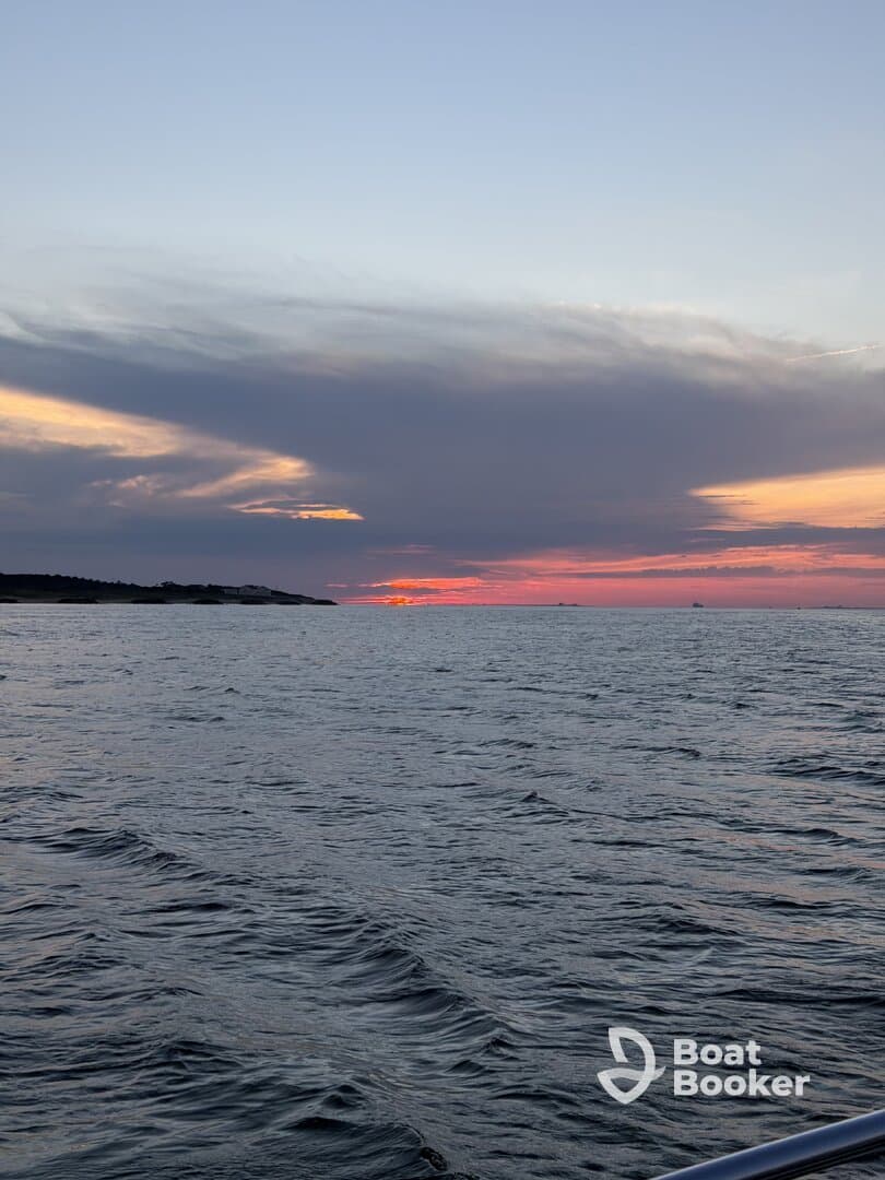 A serene sunset view over the water, showcasing the tranquil beauty of the sea — perfect for evening boat cruises.