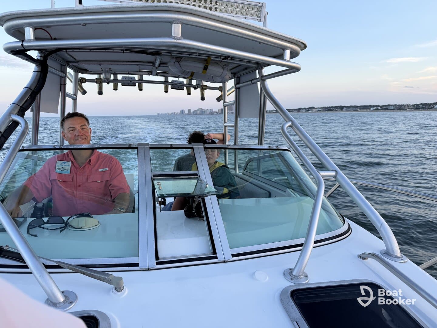 A view from the helm of a boat, featuring a captain and a passenger enjoying the ride — perfect for showcasing the boating experience.