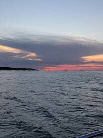 A serene sunset view over the water, showcasing the tranquil beauty of the sea — perfect for evening boat cruises.