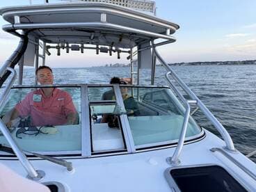 A view from the helm of a boat, featuring a captain and a passenger enjoying the ride — perfect for showcasing the boating experience.