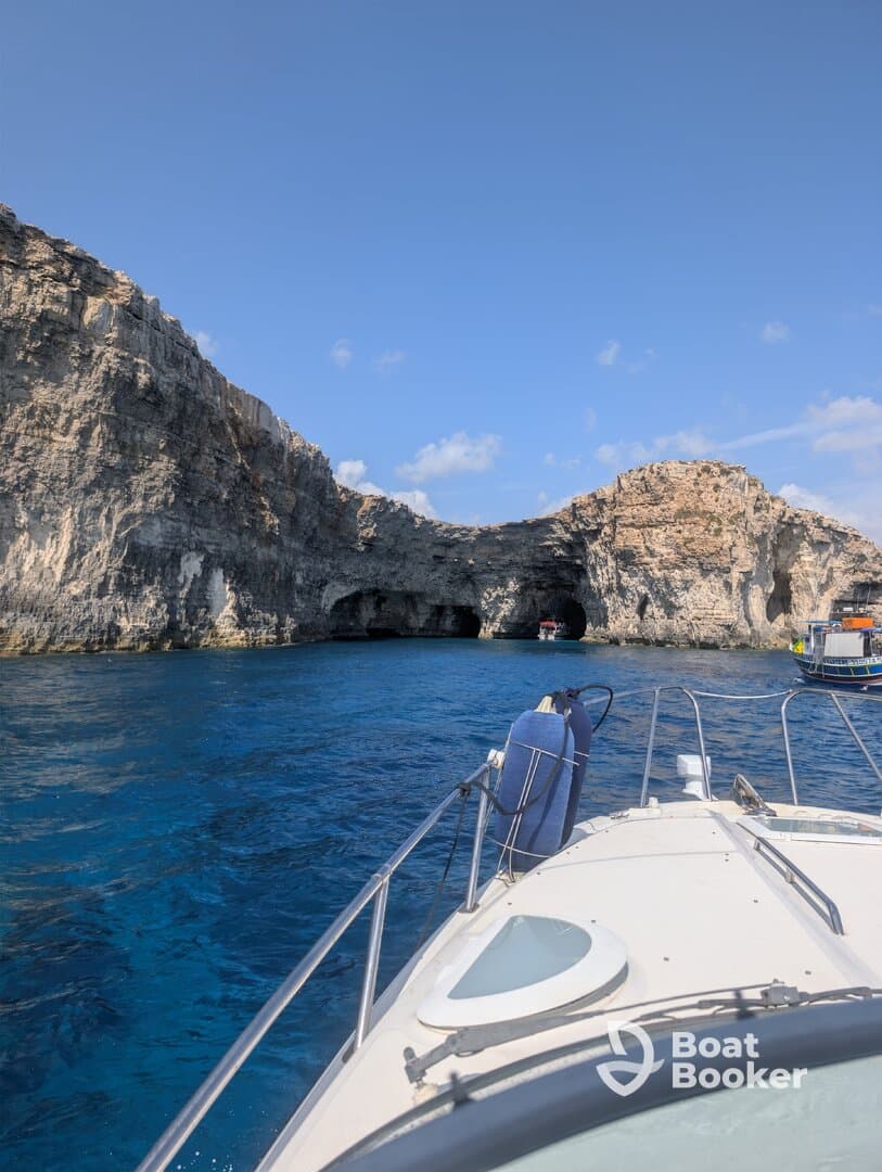 A stunning view of a boat navigating through coastal caves, showcasing the beautiful turquoise waters and rocky cliffs — perfect for adventure seekers exploring hidden gems.