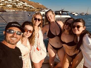 A lively group of friends poses for a selfie on a boat, enjoying a sunny day on the water — perfect for summer celebrations and memorable outings.