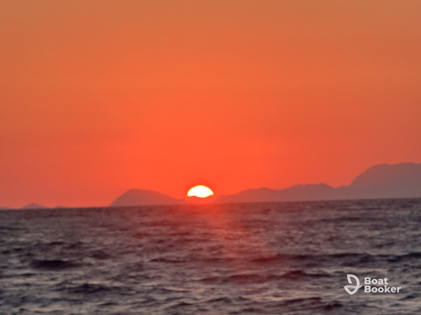 A stunning sunset over the ocean, casting vibrant hues across the sky and water — a perfect backdrop for evening boat cruises.