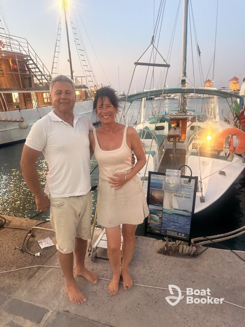 A happy couple poses at the dock next to their yacht, capturing a moment of celebration — perfect for romantic getaways or private yacht trips.