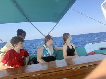 A family enjoys a scenic boat ride, gazing out at the open ocean — a perfect moment for creating lasting memories on the water.