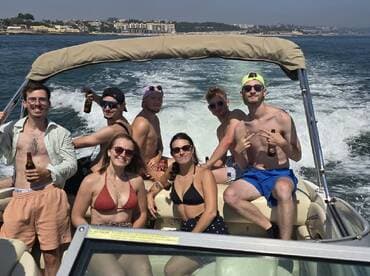 A lively group of friends enjoys a fun day on the water, celebrating with drinks aboard a boat — perfect for summer outings and memorable adventures.