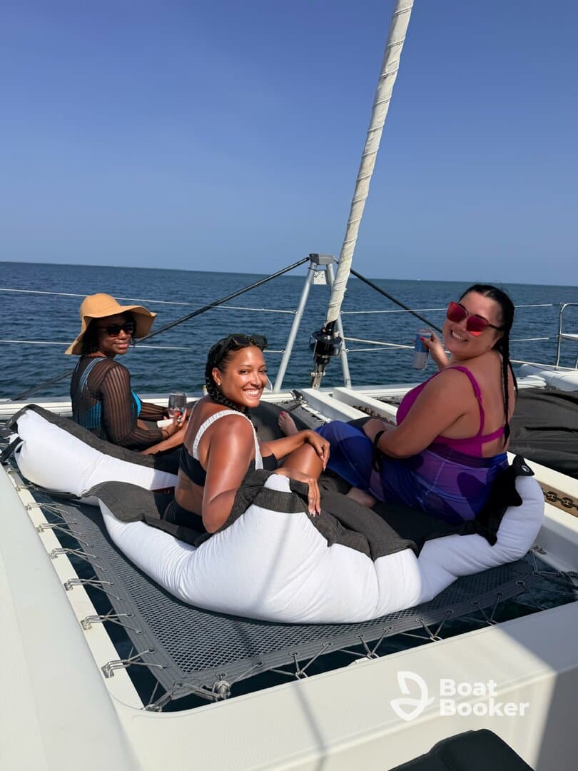 A joyful group of friends relaxes on a catamaran, enjoying the sun and sea — perfect for memorable outings and celebrations on the water.