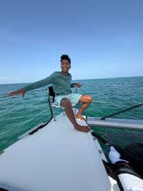 A joyful boy enjoys a sunny day sailing on a boat, capturing the essence of fun and adventure on the water.