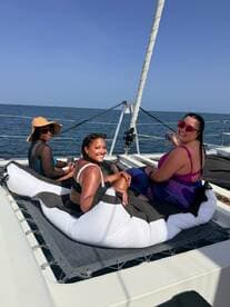 A joyful group of friends relaxes on a catamaran, enjoying the sun and sea — perfect for memorable outings and celebrations on the water.