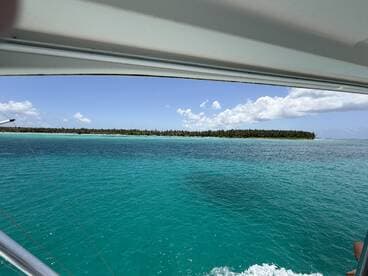 A stunning view of a lush island coastline framed by vibrant turquoise waters, perfect for showcasing the beauty of tropical destinations.