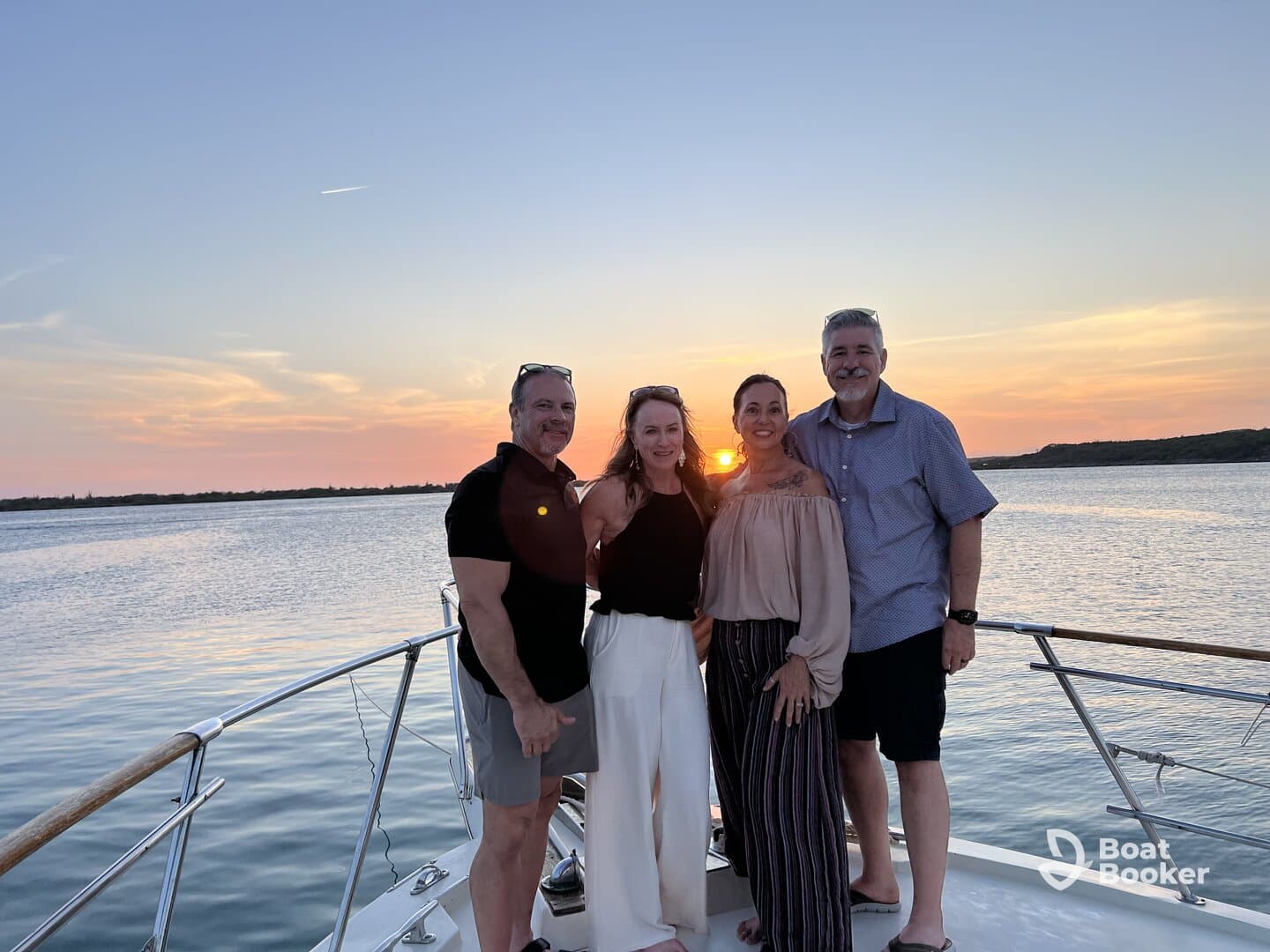 A group of friends poses for a photo on a boat at sunset, capturing a memorable moment during their cruise — perfect for celebrations and gatherings on the water.