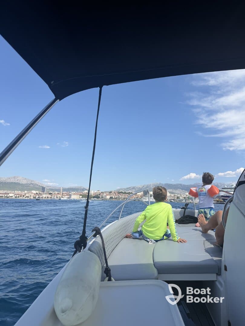 Two children enjoy the view from the deck of a boat, capturing the essence of family fun on the water.