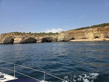 A stunning view of coastal cliffs with kayakers exploring the waters — a perfect representation of adventure and natural beauty on a boat trip.