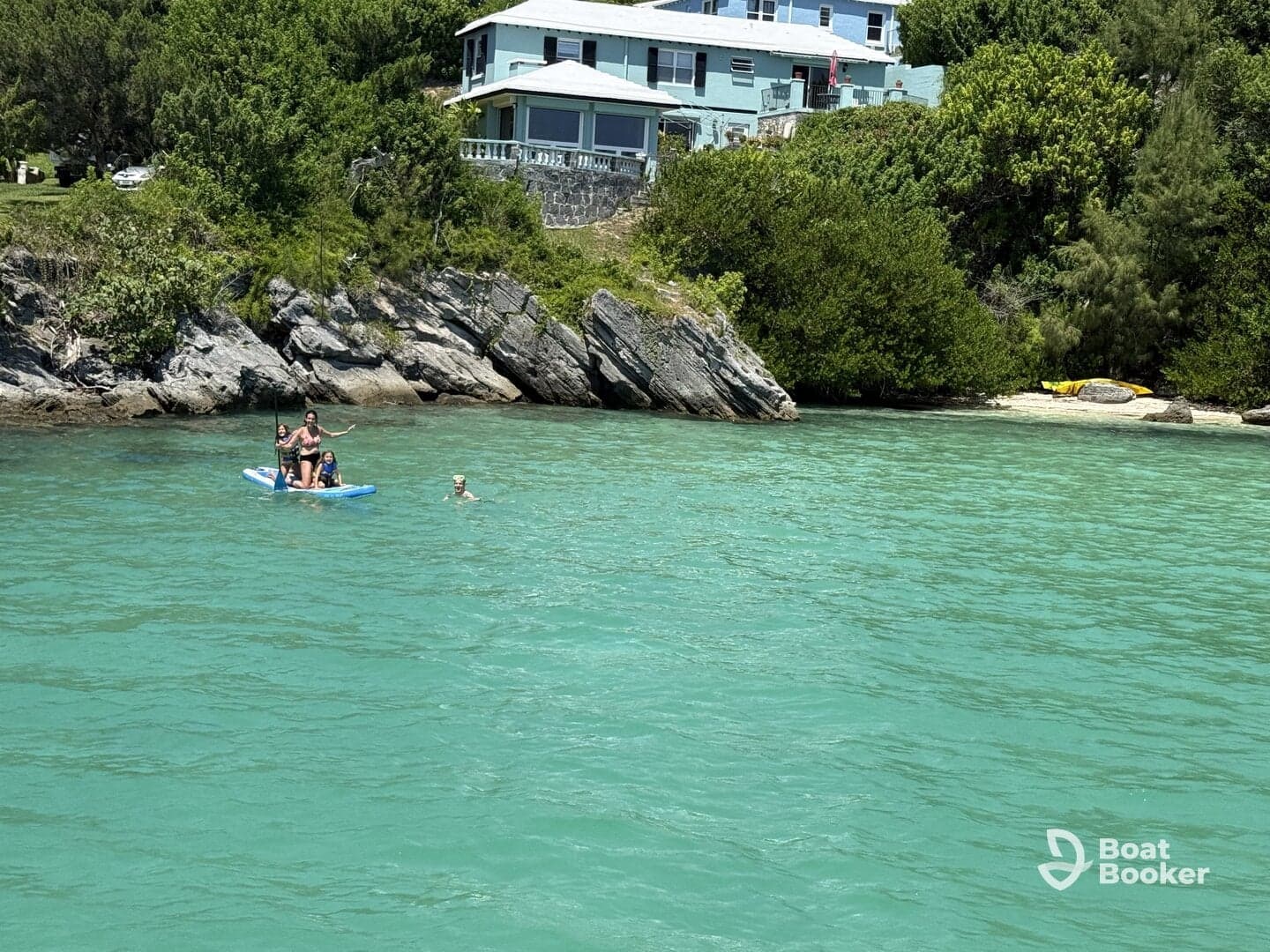 A fun day on the water with a group paddleboarding and swimming in the clear turquoise waters, perfect for family adventures and beach outings.